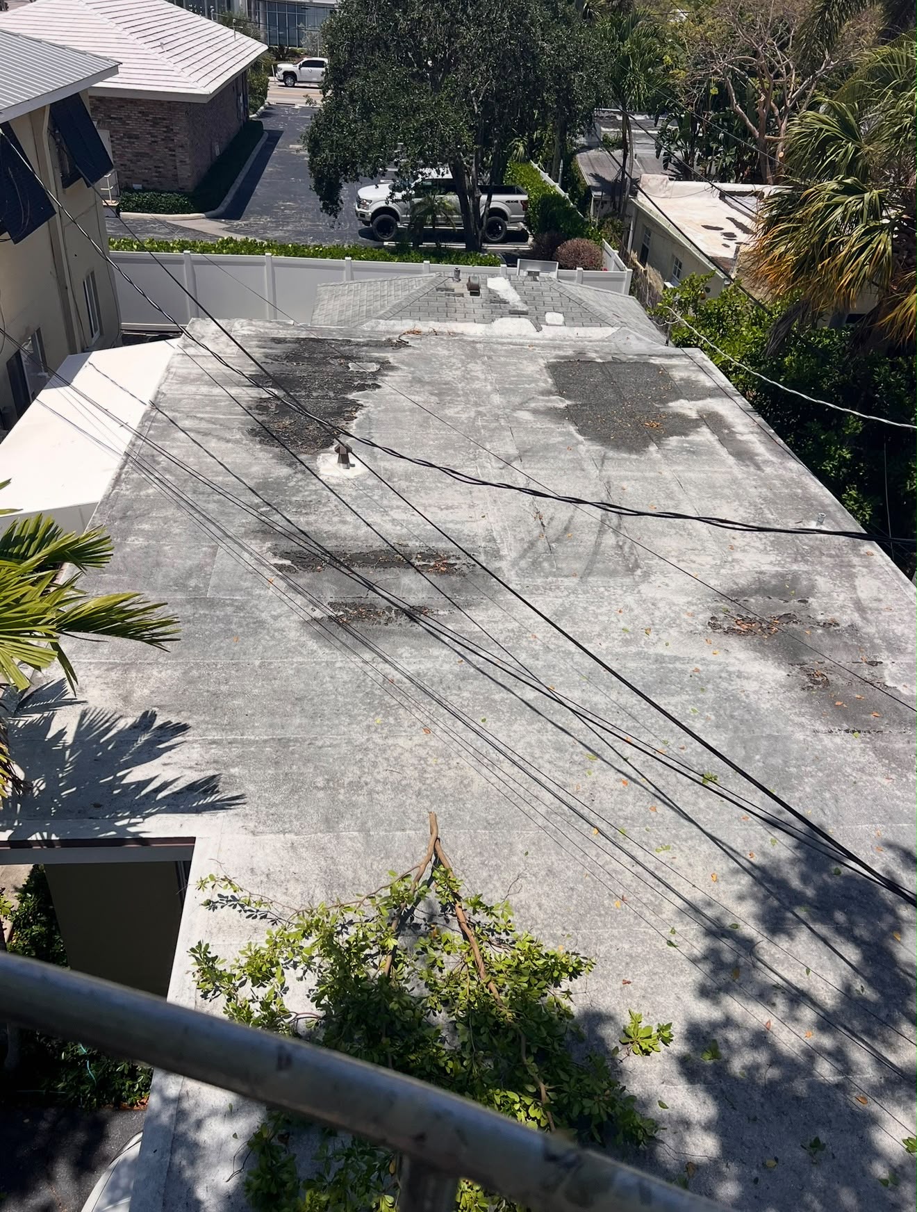 Before — A weathered and patched roof, recoated edge to edge.